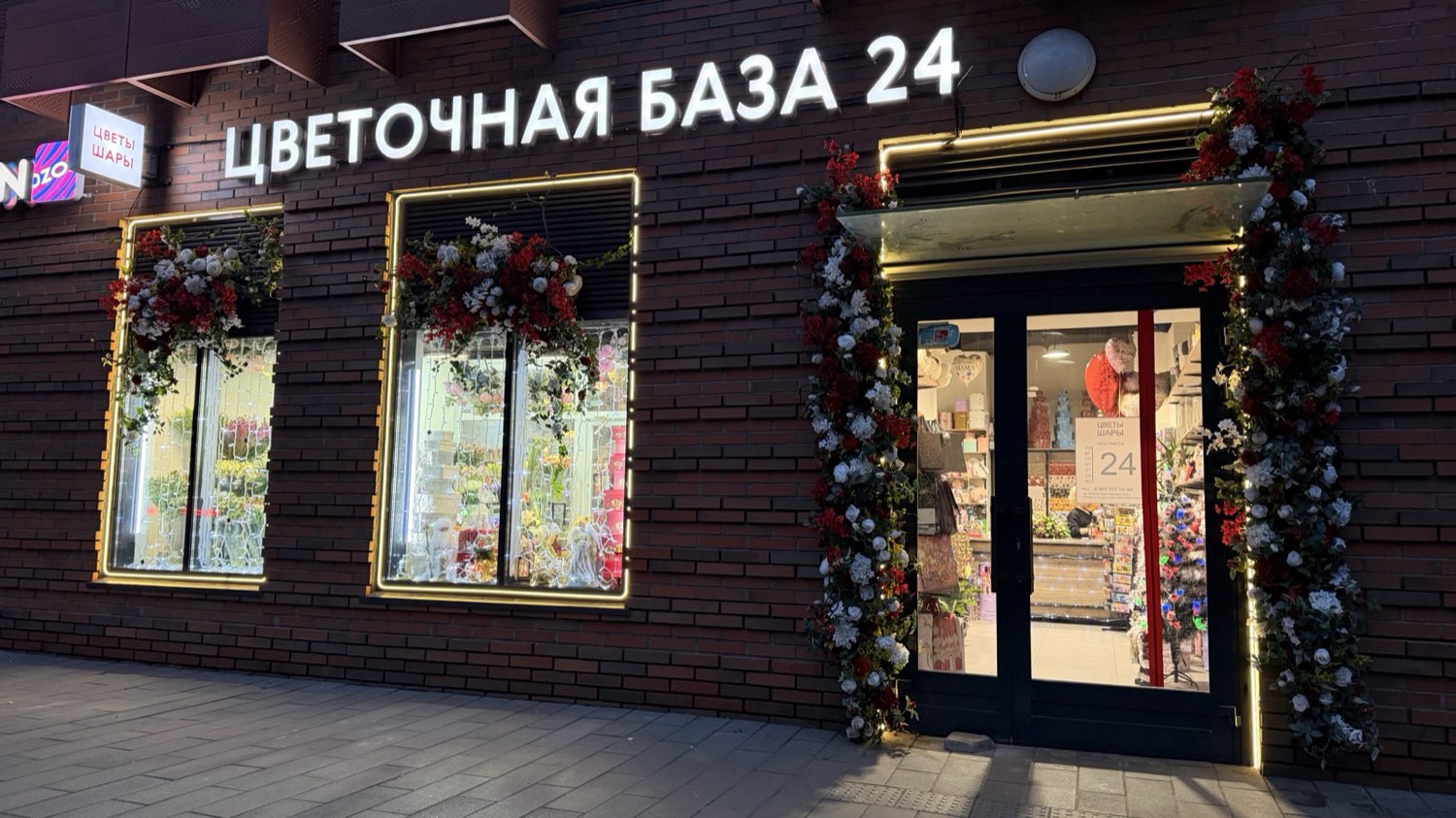Вечерняя LED подсветка витрин цветочной базы Москва: тёплый 3000K, алюминиевый профиль, кирпичный фасад, BossDiodov