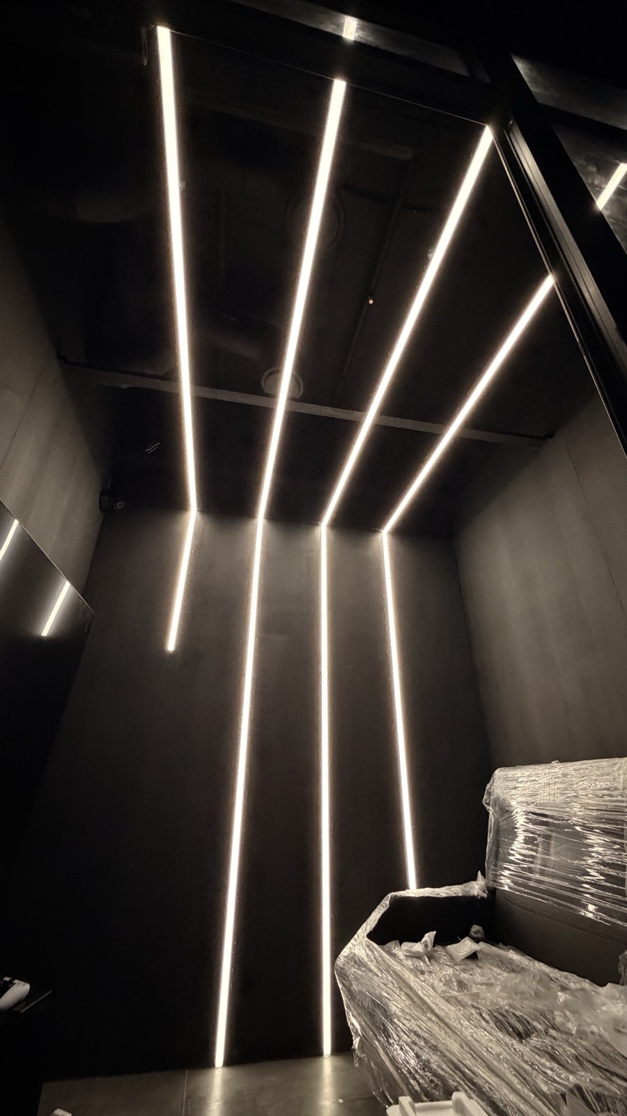 Монтаж разноуровневой подсветки Arlight в стенах Rave by Booster — белые LED-линии от пола по стене и на потолок