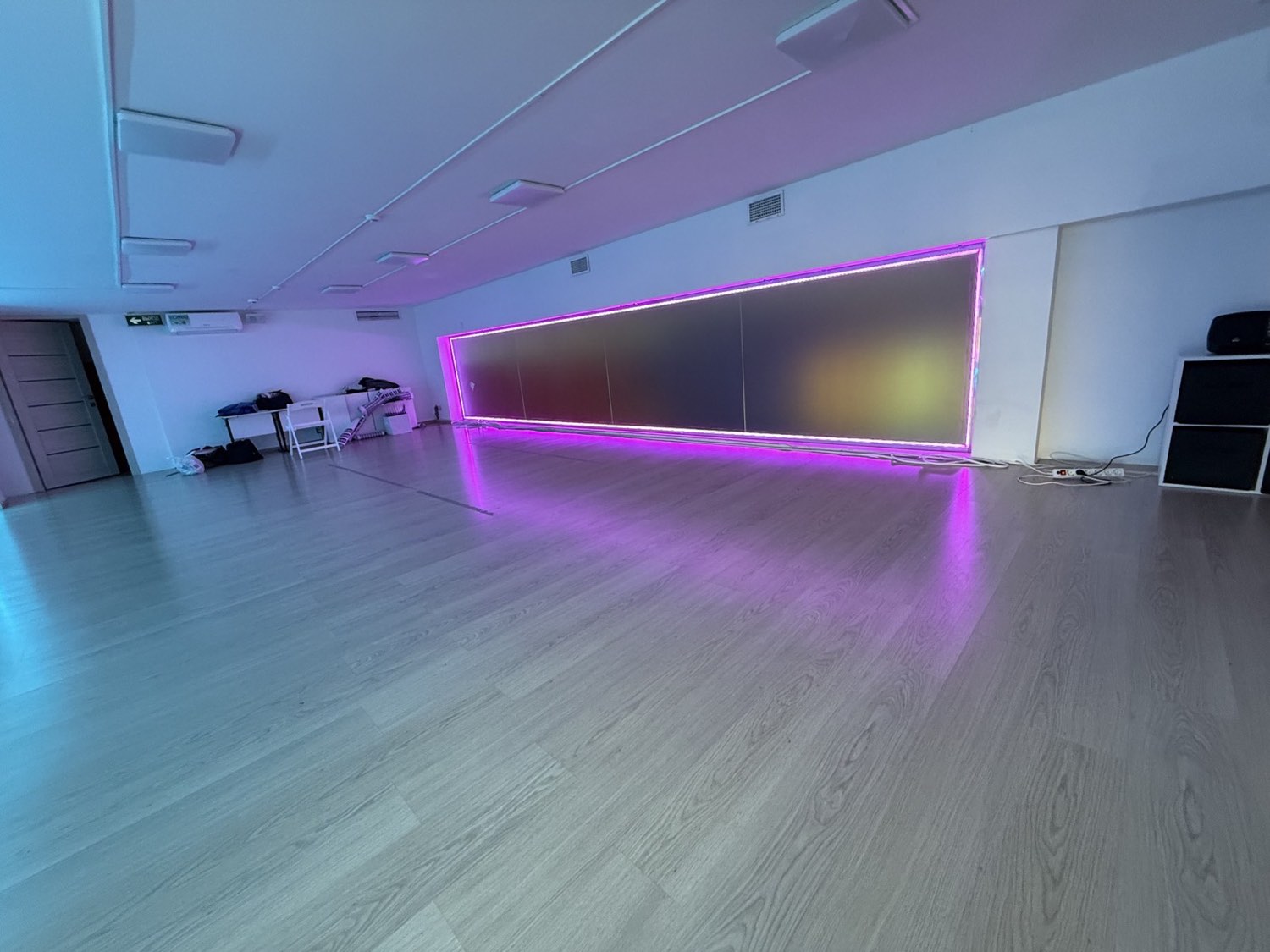 Розовый RGB-контур на стене студии танцев и мягкое цветное отражение на полу